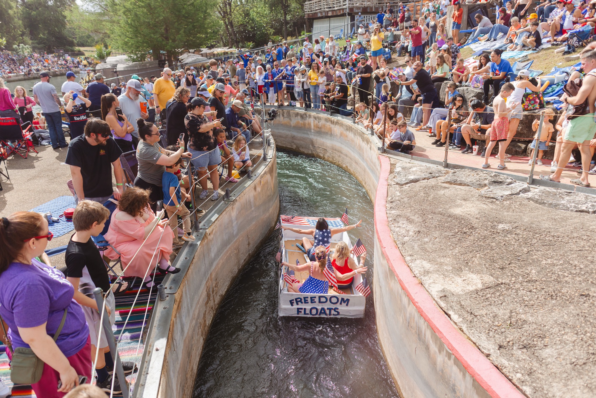 Thru the Chute boat race - Freedom Floats cardboard boat navigating the chute with thousands of spectators lining both sides